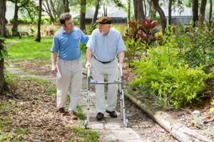 caregiver and senior man strolling